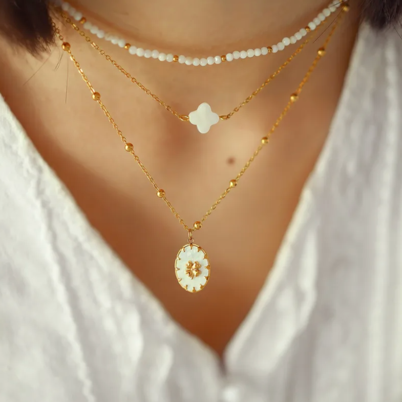 Ce collier trèfle en acier inoxydable doré, orné d’un pétale en nacre naturelle, symbolise la chance, la douceur et l’élégance discrète. Son design épuré et sa finition brillante en font un bijou délicat à porter au quotidien ou en talisman raffiné.

Matériau : Acier inoxydable couleur doré (placage PVD or 18K), nacre naturelle, hypoallergénique, résistant à l’eau et à l’oxydation.

Dimensions : Longueur de chaîne 39,5 cm + 5 cm – pendentif 1 cm – poids 1,8 g.

Design : Un trèfle blanc nacré monté sur une c