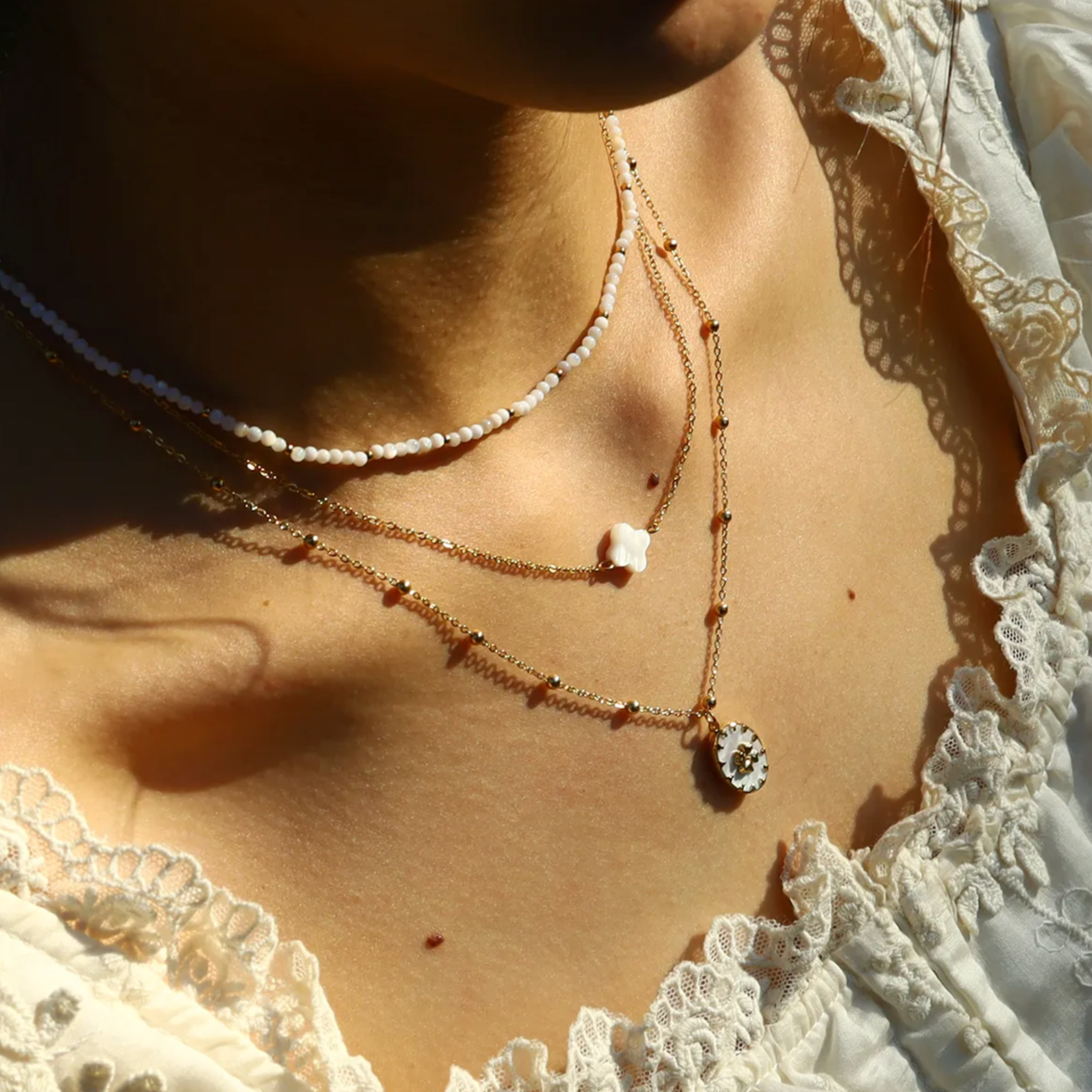 Ce collier trèfle en acier inoxydable doré, orné d’un pétale en nacre naturelle, symbolise la chance, la douceur et l’élégance discrète. Son design épuré et sa finition brillante en font un bijou délicat à porter au quotidien ou en talisman raffiné.

Matériau : Acier inoxydable couleur doré (placage PVD or 18K), nacre naturelle, hypoallergénique, résistant à l’eau et à l’oxydation.

Dimensions : Longueur de chaîne 39,5 cm + 5 cm – pendentif 1 cm – poids 1,8 g.

Design : Un trèfle blanc nacré monté sur une c