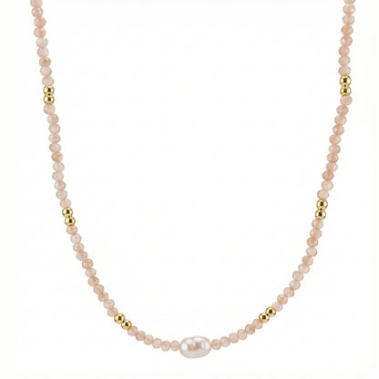 Détail perles blanches et cristaux sur collier doré