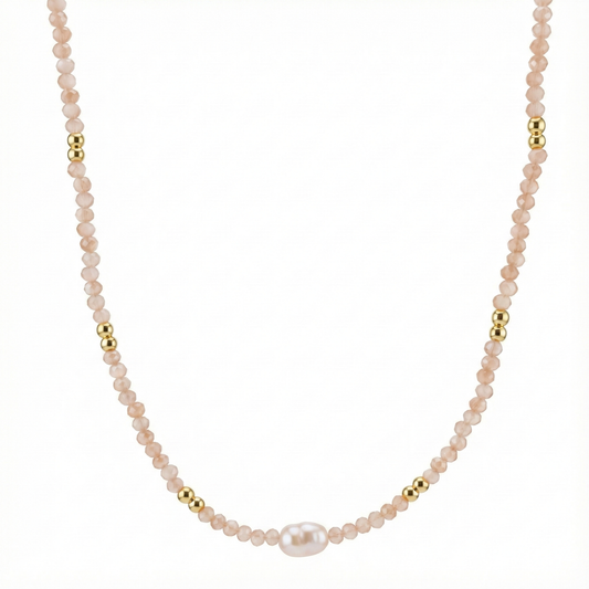 Détail perles blanches et cristaux sur collier doré